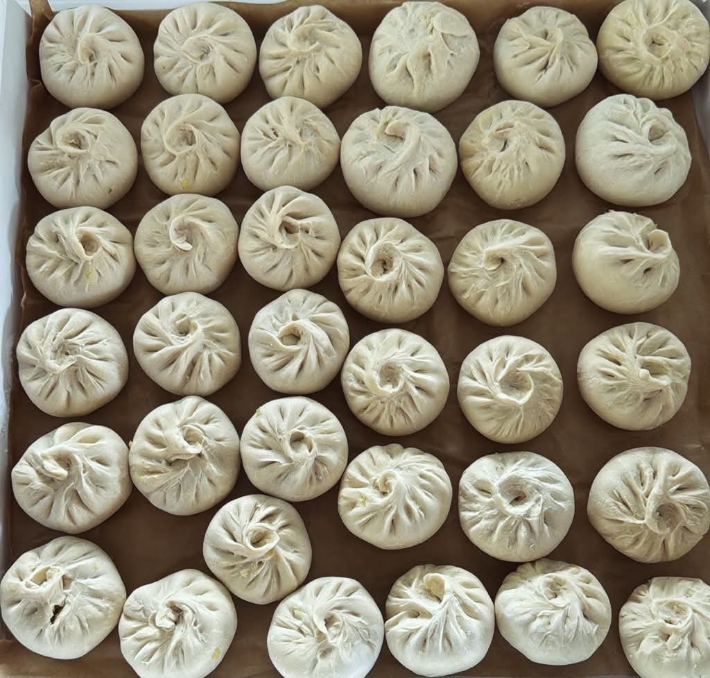 Handgeformte vegetarische Momo auf einem Tablett vor dem Tiefkühlen